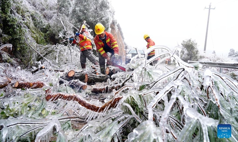 Staff members remove the branches crushed by snow and ice in Jinxiu Town of Jinxiu Yao Autonomous County, south China's Guangxi Zhuang Autonomous Region, Feb. 21, 2022.(Photo: Xinhua)