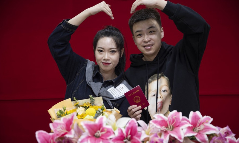 A couple poses for a photo at a marriage registry of Daoli District in Harbin, capital of northeast China's Heilongjiang Province, Feb. 22, 2022. (Photo: Xinhua)