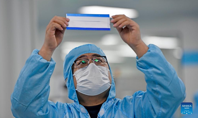 A worker checks a mask at a workshop of Naton Medical Protective Equipment (Tianjin) Co., Ltd. in Tianjin, north China, Feb 23, 2022.Photo:Xinhua