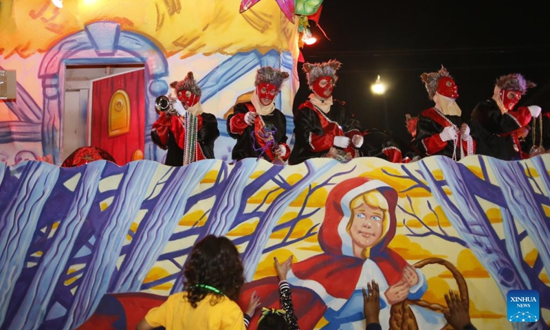 Performers interact with the crowd during the Krewe of Iris parade in New Orleans, Louisiana, the United States, Feb. 26, 2022. (Photo by Lan Wei/Xinhua)