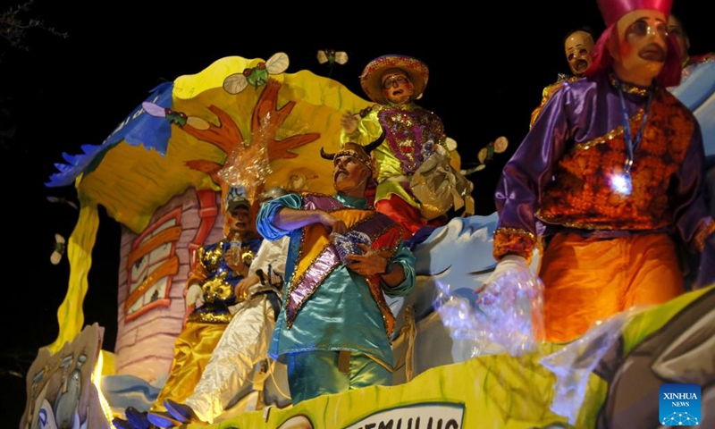 Performers interact with the crowd during the Krewe of Iris parade in New Orleans, Louisiana, the United States, Feb. 26, 2022. (Photo by Lan Wei/Xinhua)