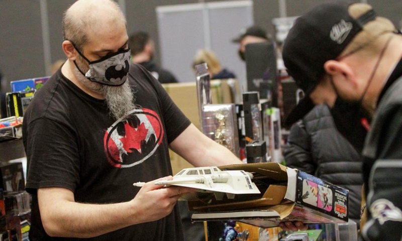 A visitor looks at a toy at the Vancouver Comic and Toy Show in Vancouver, British Columbia, Canada, on Feb. 27, 2022. The Vancouver Comic and Toy Show which was held here on Sunday, features collectible toys, superhero memorabilia, comic books and other similar pop culture items that drawing thousands of collectors and enthusiasts to participate. (Photo by Liang Sen/Xinhua)