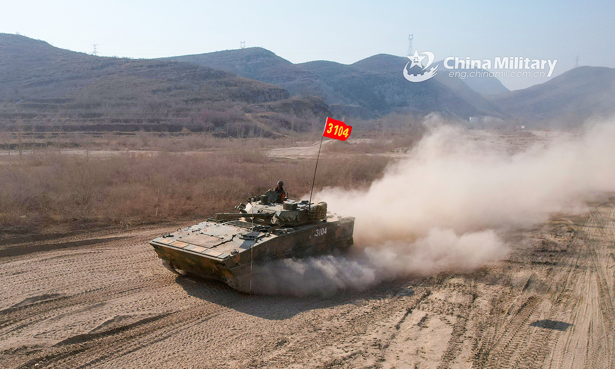 Soldiers assigned to a brigade under the PLA 82nd Group Army drive an infantry fighting vehicle on a dirt road during a driving skills training exercise on February 24, 2022. (eng.chinamil.com.cn/Photo by Sun Tongkai)