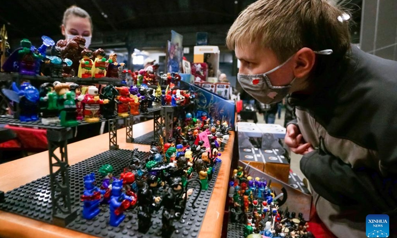 A visitor takes a closer look at some Lego figures at the Vancouver Comic and Toy Show in Vancouver, British Columbia, Canada, on Feb. 27, 2022. The Vancouver Comic and Toy Show which was held here on Sunday, features collectible toys, superhero memorabilia, comic books and other similar pop culture items that drawing thousands of collectors and enthusiasts to participate. (Photo by Liang Sen/Xinhua)