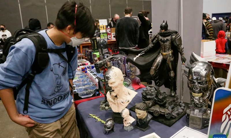 A visitor takes a look at some model figures at the Vancouver Comic and Toy Show in Vancouver, British Columbia, Canada, on Feb. 27, 2022. The Vancouver Comic and Toy Show which was held here on Sunday, features collectible toys, superhero memorabilia, comic books and other similar pop culture items that drawing thousands of collectors and enthusiasts to participate. (Photo by Liang Sen/Xinhua)