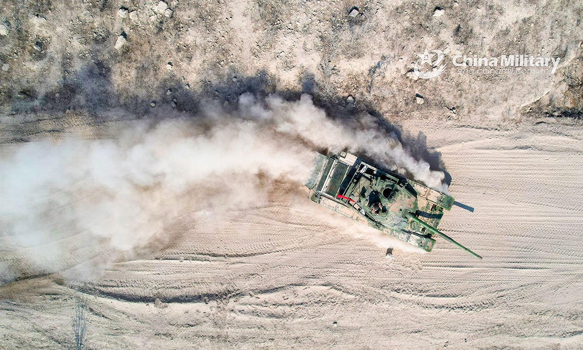 An armored vehicle attached to a brigade under the PLA 82nd Group Army rumbles through a mound of dust during a driving skills training exercise on February 24, 2022. (eng.chinamil.com.cn/Photo by Sun Tongkai)