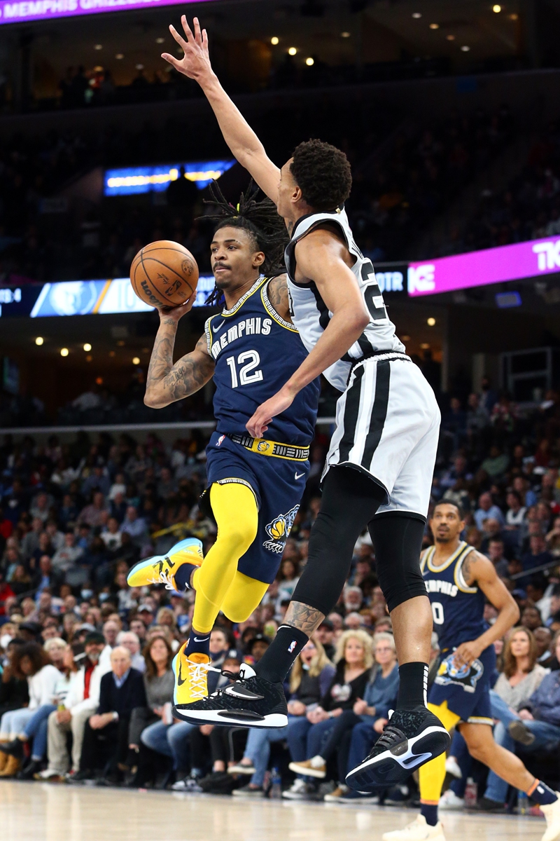 Memphis Grizzles guard Ja Morant (left) passes the ball against San Antonio Spurs guard-forward Devin Vassell on February 28, 2022 in Memphis, Tennessee. Photo: IC