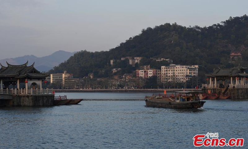 Photo shows a boat passing through Guangji Bridge in Chaozhou, South China's Guangdong Province, Feb. 28, 2022. Guangji Bridge is located on the Hanjiang River in the east of the ancient city of Chaozhou. The pontoon bridge is connected by wooden boats, which are connected in the morning and disconnected in the evening to facilitate the navigation of passing ships. (Photo: China News Service/Chen Chuhong)