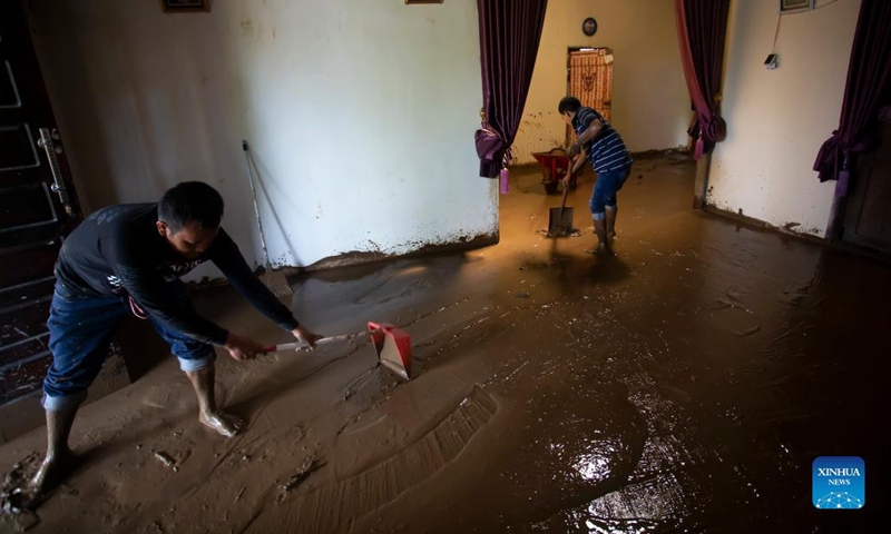 People clean mud at their house after floods triggered by heavy rains and rising waters of the Batang Nango river after a 6.1-magnitude quake in Nagari Kajai village of Pasaman Barat district, West Sumatra, Indonesia, March 1, 2022.(Photo: Xinhua)