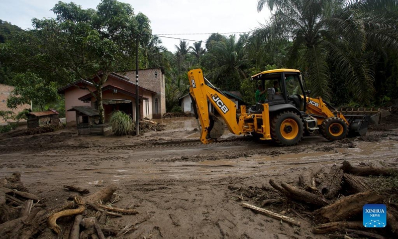 An excavator runs on the muddy road after floods triggered by heavy rains and rising waters of the Batang Nango river after a 6.1-magnitude quake in Nagari Kajai village of Pasaman Barat district, West Sumatra, Indonesia, March 1, 2022.(Photo: Xinhua)