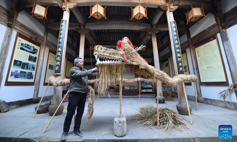 A villager checks the straw-woven dragon ahead of the Longtaitou Day in Shuyuan Village, Huizhou District of Huangshan, east China's Anhui Province, March 2, 2022.Photo:Xinhua