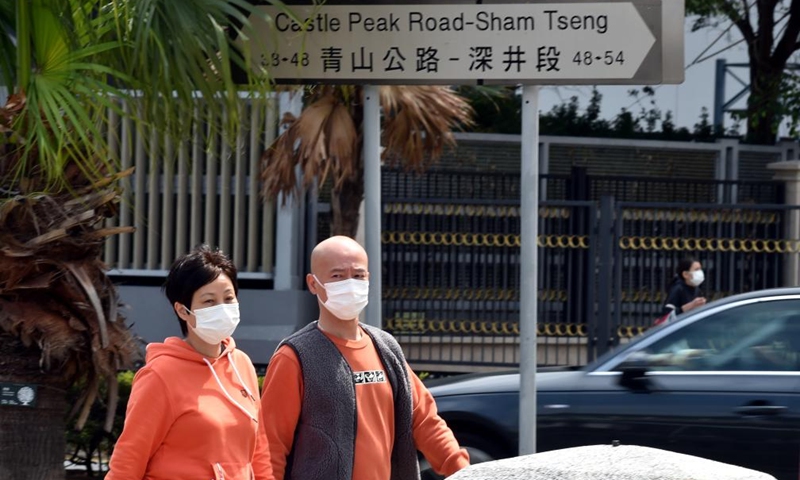 People wearing face masks walk on a street in south China's Hong Kong, March 6, 2022.Photo:Xinhua