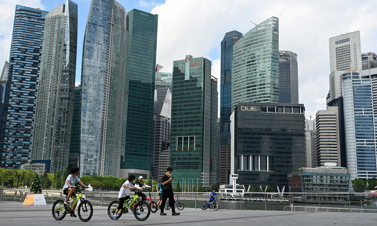 People ride bicycles along the promenade at Marina Bay in Singapore on December 21, 2021. Photo: AFP