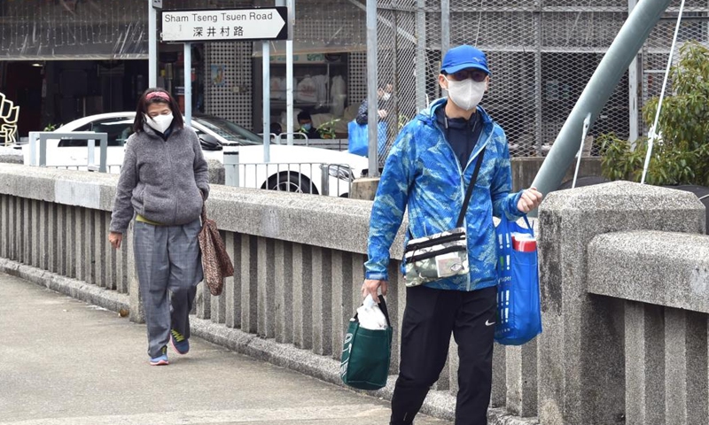 People wearing face masks walk on a street in south China's Hong Kong, March 6, 2022.Photo:Xinhua