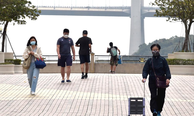 People wearing face masks walk on a street in south China's Hong Kong, March 6, 2022.Photo:Xinhua