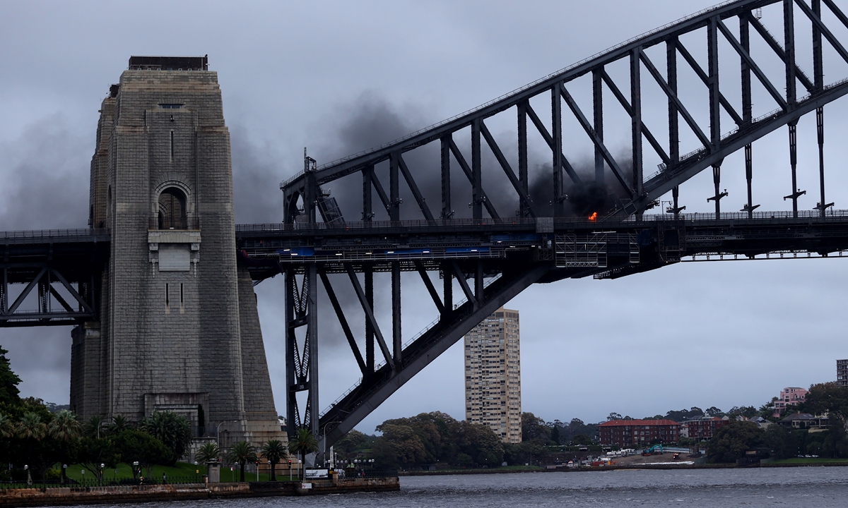 A plume of fire is seen on the Sydney Harbour Bridge in Sydney, Australia on March 7, 2022. A car burst into flames when it crashed with another vehicle just before 7 am. The bridge has been closed to traffic in both directions. Photo: VCG