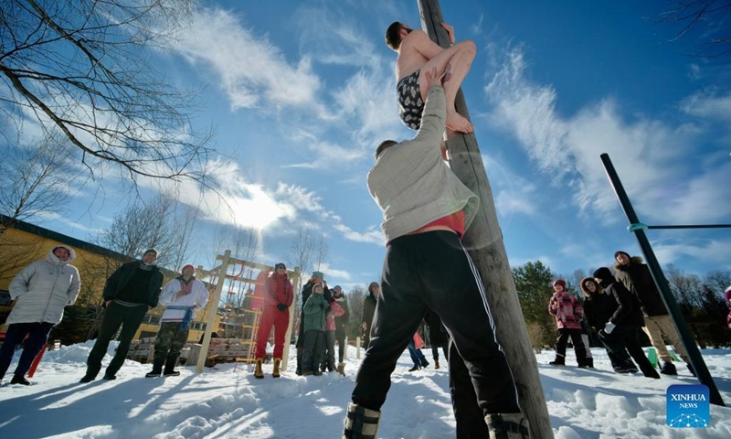 A man climbs a pole during Maslenitsa celebrations in Gamzyuki village, Kaluga region, Russia, on March 6, 2022. Maslenitsa is a traditional holiday to celebrate the beginning of spring.(Photo: Xinhua)