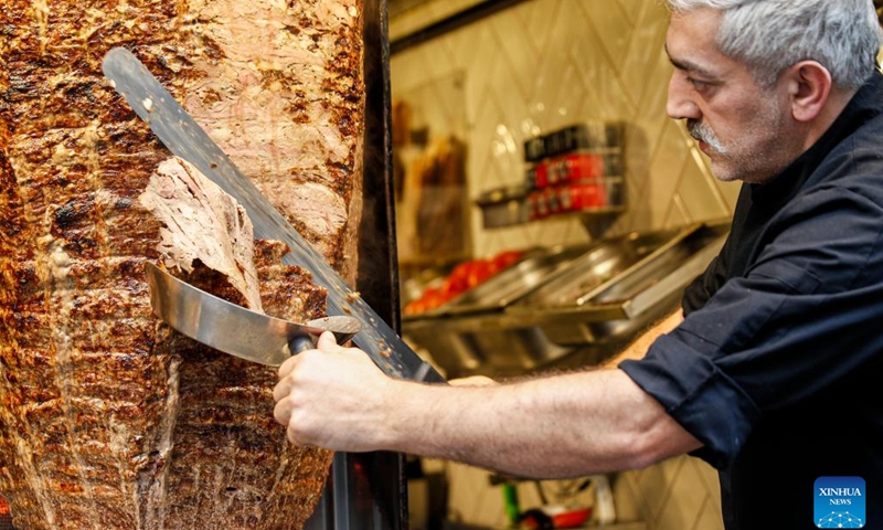 A staff member works at a Turkish doner kebab restaurant in Istanbul, Turkey, March 5, 2022. The streets of Turkey's biggest city Istanbul are filled with a variety of delicious foods, desserts, drinks, attracting Turkish people and tourists.(Photo: Xinhua)