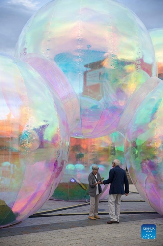 Photo taken on March 9, 2022 shows the giant bubbles displayed in front of the Canberra Theatre Centre during the Enlighten Festival in Canberra, Australia. The annual Enlighten Festival runs this month with landmark buildings illuminated with colorful lights.(Photo: Xinhua)