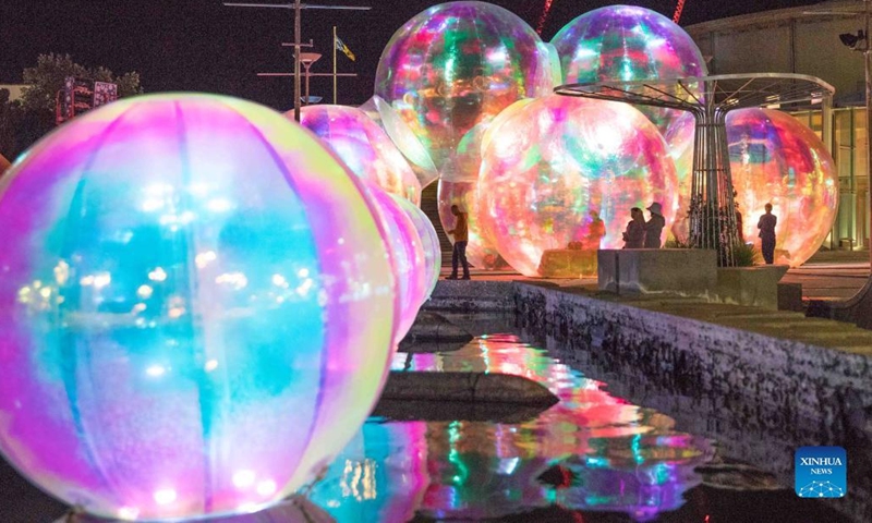 Photo taken on March 9, 2022 shows the illuminated giant bubbles displayed in front of the Canberra Theatre Centre during the Enlighten Festival in Canberra, Australia. The annual Enlighten Festival runs this month with landmark buildings illuminated with colorful lights.(Photo: Xinhua)