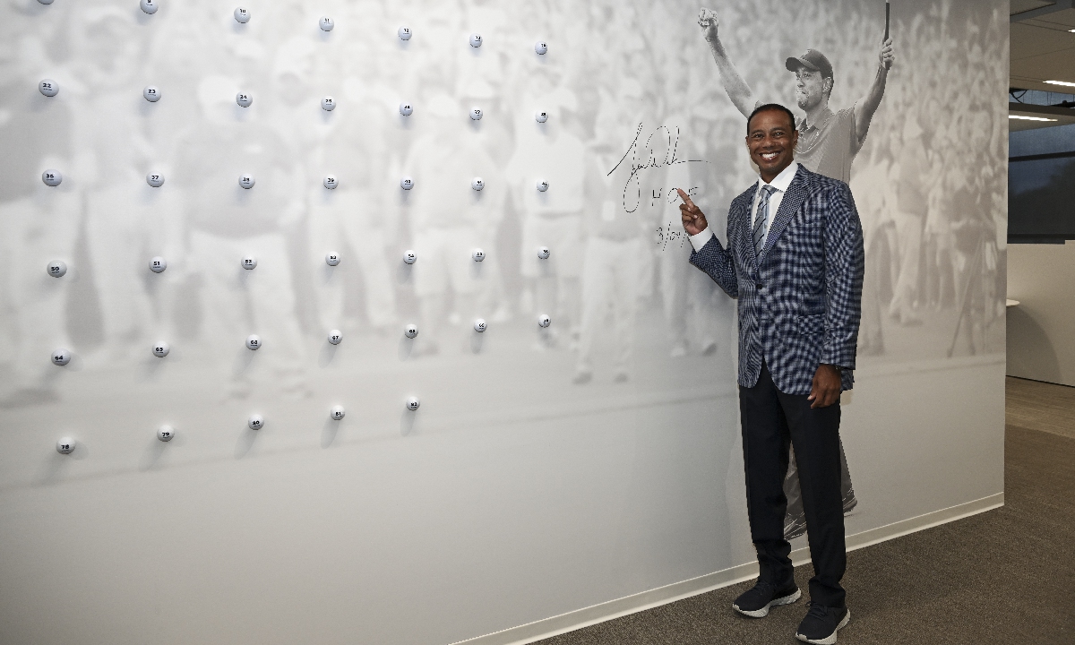 Tiger Woods signs a wall graphic of himself on March 9, 2022, in Ponte Vedra Beach, Florida. Photo: VCG