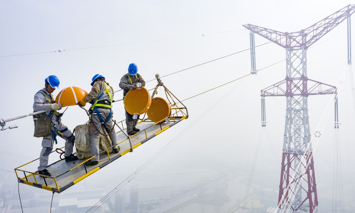 On March 14, 2022, on the edge of the Yangtze River in Wuhu, East China's Anhui Province, construction workers of Anhui Power Transmission and Transformation Engineering installed ultra-high voltage (UHV) transmission lines across the river at an altitude of 270 meters. On the same day, the ±800-kilovolt UHV transmission project finished.Photo: cnsphoto
