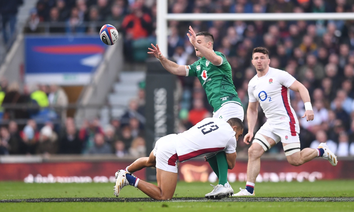 Johnny Sexton (center) of Ireland offloads from the tackle by Joe Marchant of England on March 12, 2022 in London, England. Photo: IC