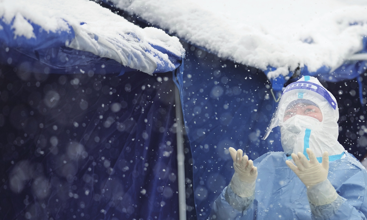 A medical staff takes a rest at a nucleic acid sampling site in Dongcheng district, Beijing on March 18. Beijing snowed heavily on the same day, but medical staff and community workers still worked at the frontline of anti-epidemic efforts. Photo: cnsphotos