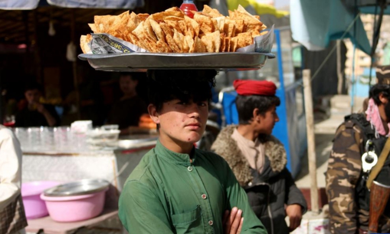 An Afghan boy sells Samosa near the Sakhi Shrine during the celebration of annual Nawroz festival in Kabul, capital of Afghanistan, March 21, 2022. (Photo: Xinhua)