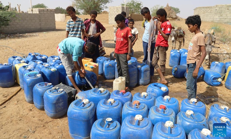 Yemeni children wait to fill their plastic tanks with water at a charitable water station in Abs District, Hajjah province, Yemen, on March 21, 2022.(Photo: Xinhua)