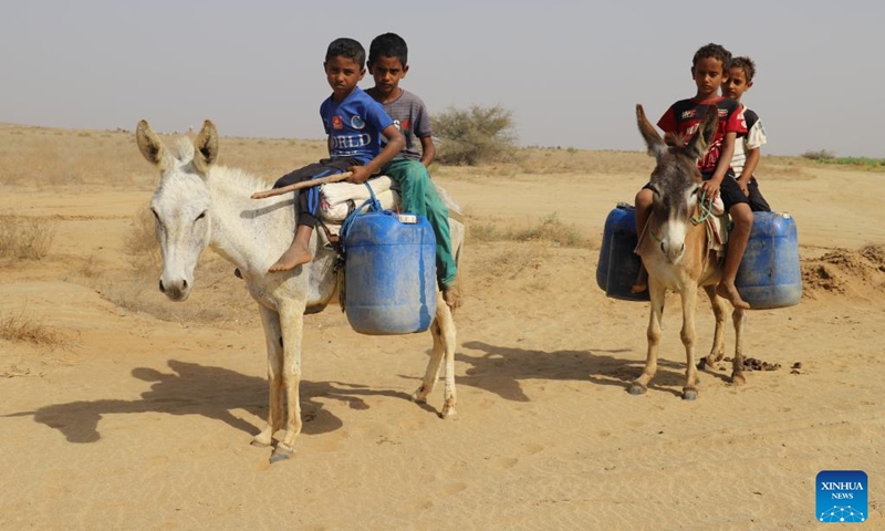 Yemeni children wait to fill their plastic tanks with water at a charitable water station in Abs District, Hajjah province, Yemen, on March 21, 2022.(Photo: Xinhua)