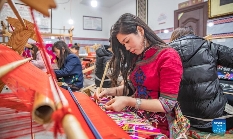 Women make products of Xilankapu, which is a kind of Tujia brocade, at a studio in Xiaonanhai Town of Qianjiang District in southwest China's Chongqing, March 22, 2022. Xilankapu, also known as knitting Floral Bedclothes, was listed as national intangible cultural heritage in 2006.(Photo: Xinhua)