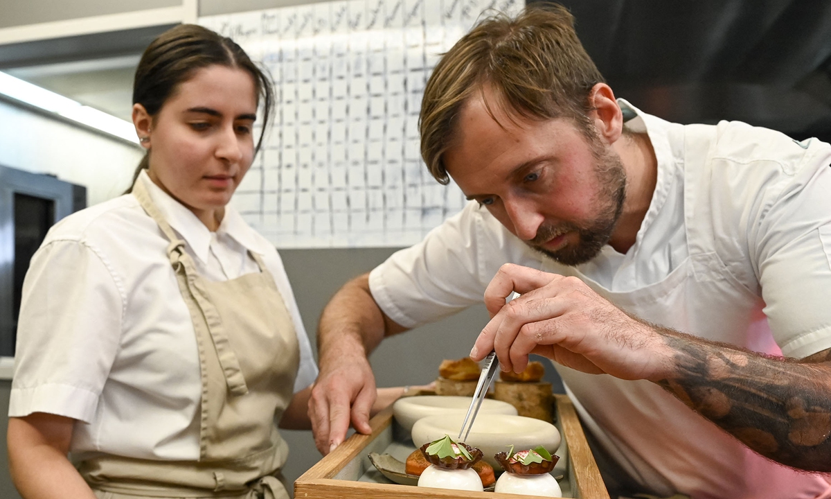 French Michelin-starred chef Loic Villemin (right) prepares meals in the kitchen of his restaurant 