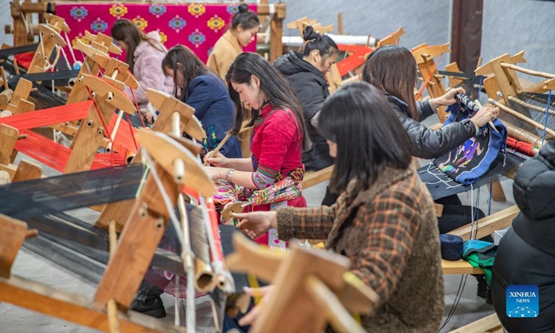 Women make products of Xilankapu, which is a kind of Tujia brocade, at a studio in Xiaonanhai Town of Qianjiang District in southwest China's Chongqing, March 22, 2022. Xilankapu, also known as knitting Floral Bedclothes, was listed as national intangible cultural heritage in 2006.(Photo: Xinhua)