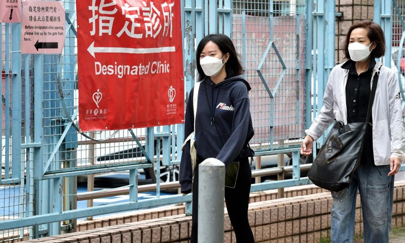 Citizens wearing face masks walk to a clinic in Hong Kong, south China, March 22, 2022.(Photo: Xinhua)