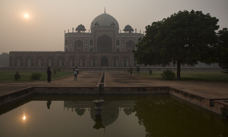 People take pictures near Humayun's Tomb, a UNESCO World Heritage site, amid thick smog in New Delhi, India, Nov. 4, 2020. (Xinhua/Javed Dar)