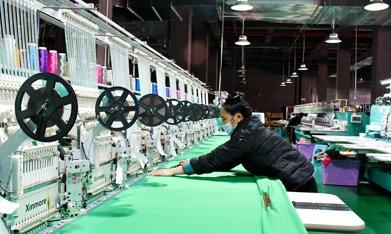 An employee works on a polyester sewing line in an intelligent workshop in Congjiang county, Southwest China's Guizhou Province, on April 7, 2022. In recent years, with the upgradng of intelligent workshops, Congjiang realized automation and intelligent control in production processes. Local housewives were trained to work in these facilities and increased their families' incomes. Photo: VCG