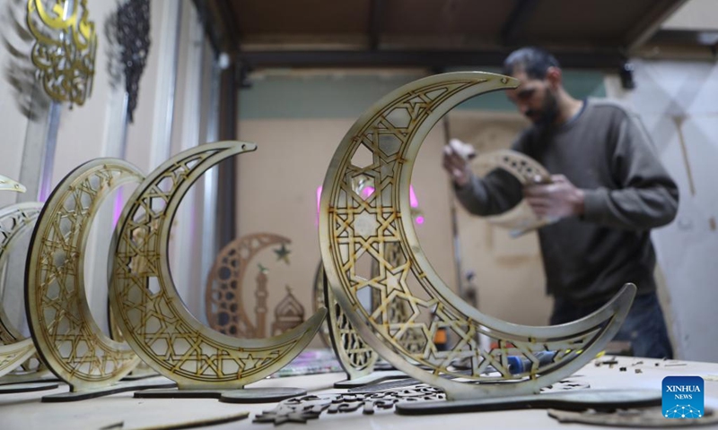 A man makes wooden decorations at a family workshop ahead of the Islamic holy month of Ramadan, in the West Bank city of Hebron, on March 29, 2022.(Photo: Xinhua)