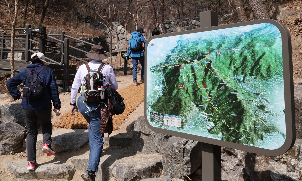 Hikers climb the southern trail of Bugaksan Mountain, located behind the Blue House, in Seoul, South Korea on April 6, 2022. This is the first time that the mountain has been fully opened to the public in 54 years. President-elect Yoon Suk-yeol's plan to move out of the current presidential Blue House complex returns the gardens, parks, and traditional buildings in the complex that were cordoned off to the public. Photo: VCG