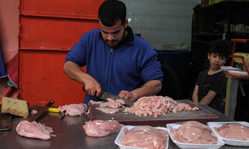 A vendor cuts chicken meat at a market in Gaza City, April 6, 2022.(Phoo: Xinhua)