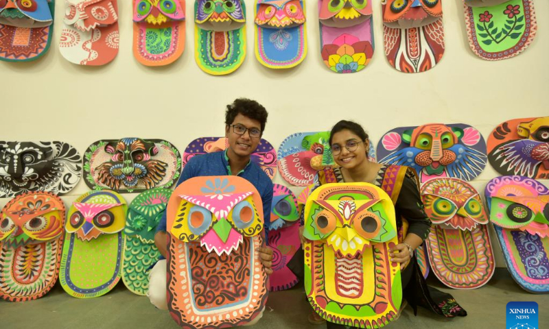 Students pose for a photo with traditional paper works made for the Bengali New Year in Dhaka, Bangladesh, April 10, 2022. The Bangla New Year is usually celebrated amid festivities every year on April 14. Photo: Xinhua