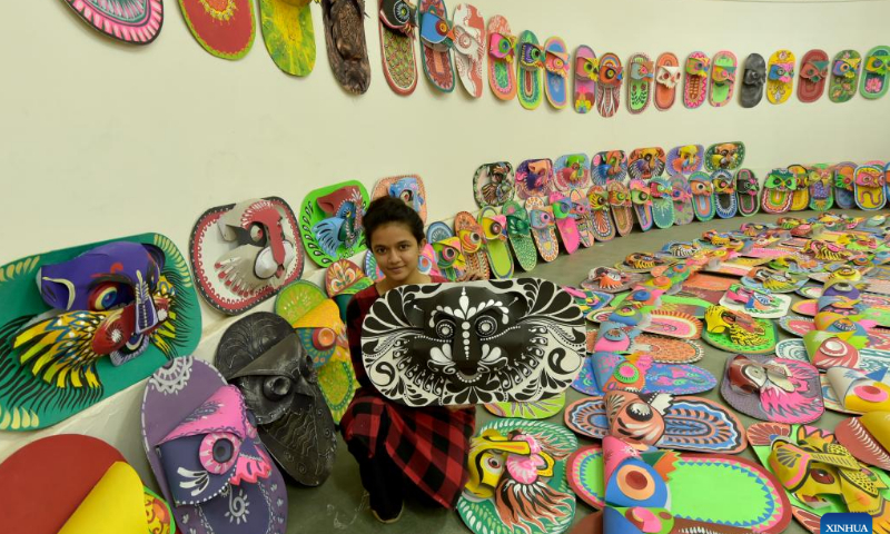 A student poses for a photo with a traditional paper work made for the Bengali New Year in Dhaka, Bangladesh, April 10, 2022. The Bangla New Year is usually celebrated amid festivities every year on April 14. Photo: Xinhua