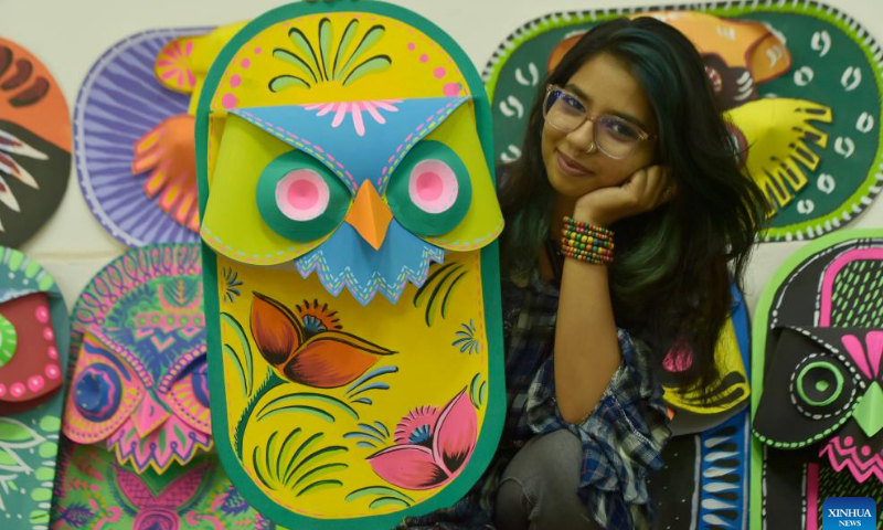 A student poses for a photo with a traditional paper work made for the Bengali New Year in Dhaka, Bangladesh, April 10, 2022. The Bangla New Year is usually celebrated amid festivities every year on April 14. Photo: Xinhua