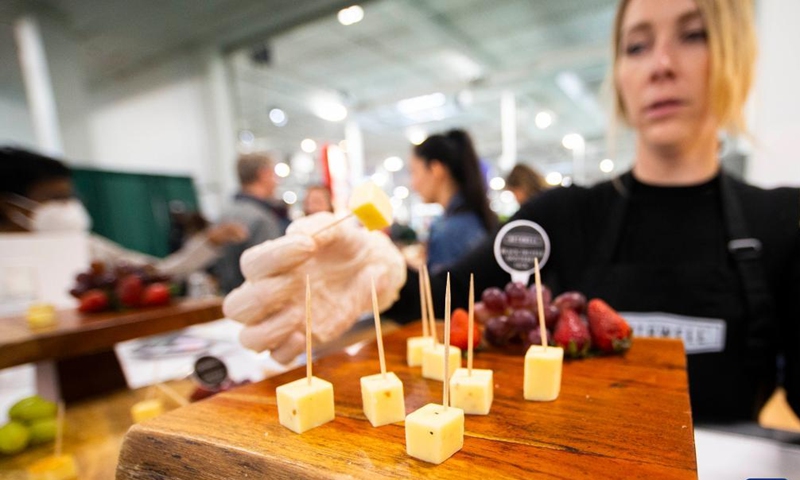 An exhibitor offers sample food to visitors during the Spring Cottage Life Show in Mississauga, the Greater Toronto Area, Canada, on April 9, 2022.Photo:Xinhua