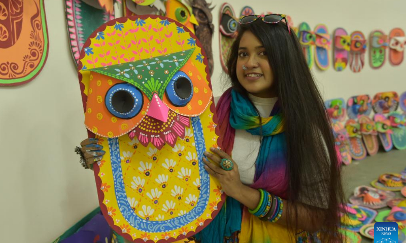 A student poses for a photo with a traditional paper work made for the Bengali New Year in Dhaka, Bangladesh, April 10, 2022. The Bangla New Year is usually celebrated amid festivities every year on April 14. Photo: Xinhua