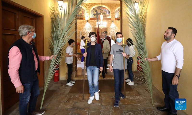 Christian believers hold branches of palm during a celebration of Palm Sunday in Beirut, Lebanon, on April 10, 2022.Photo:Xinhua