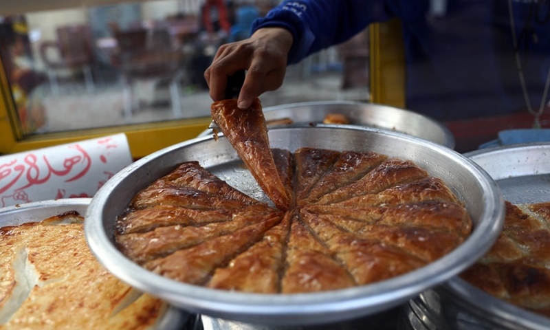 A vendor shows traditional sweets known as Golash during the holy month of Ramadan in Cairo, Egypt, on April 10, 2022.Photo:Xinhua