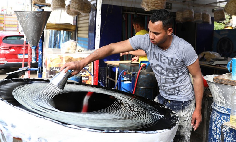 A baker makes traditional sweets known as Kanafeh during the holy month of Ramadan in Cairo, Egypt, on April 10, 2022.Photo:Xinhua