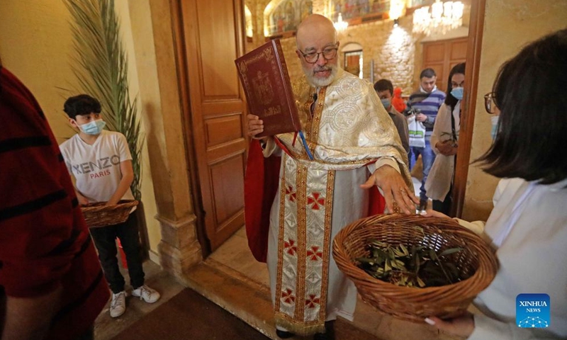 A Christian clergyman blesses the olive branch during a celebration of Palm Sunday in Beirut, Lebanon, on April 10, 2022.Photo:Xinhua