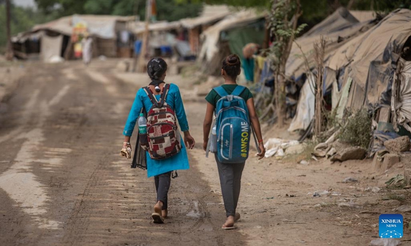 Girls walk to a makeshift school under a metro bridge in New Delhi, India, April 12, 2022. The free school underneath the metro bridge is run by a group of undergraduate students for children who come from the slums situated adjacent to the Yamuna river.(Photo: Xinhua)